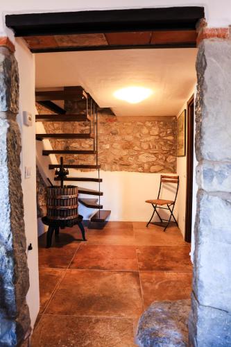 a room with a stone wall and a spiral staircase at Ca'Toni in Bagnone