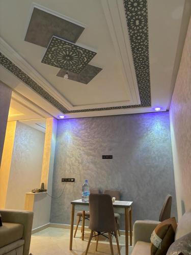 a room with a table and chairs and a ceiling at Appartement Marjana in Meknès