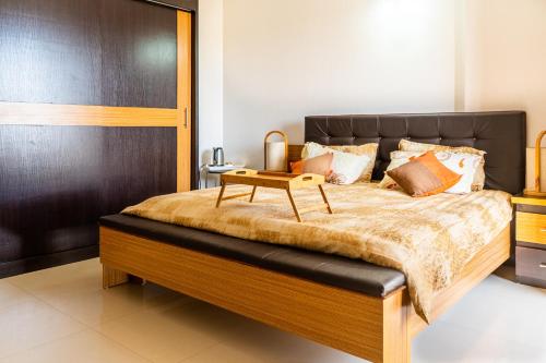 a bedroom with a large bed with a table on it at Appartement African Chic in Dakar