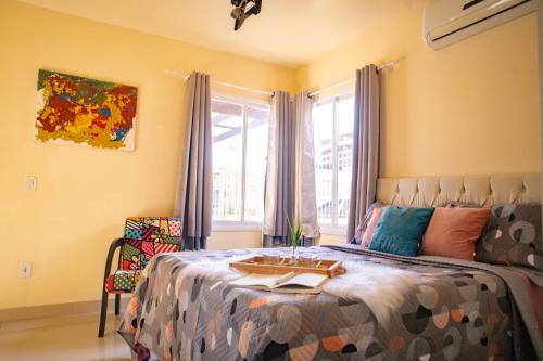 a bedroom with a bed with a table on it at Casa 3 min Shopping Pelotas- Com 1 Suíte, 2 Quartos Climatizados, Piscina e Estacionamento 2 carros in Pelotas
