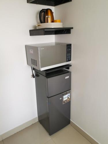 a microwave oven sitting on top of a refrigerator at Appartement African Chic in Dakar