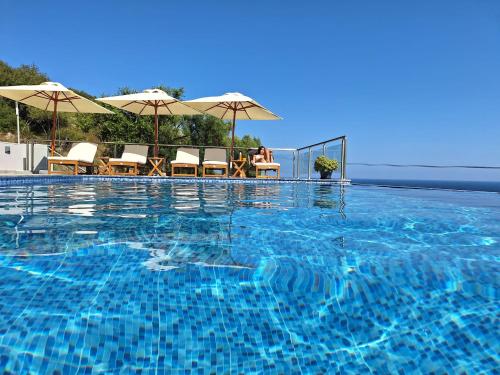 una grande piscina con sedie e ombrelloni di Sarti Thea a Sárti