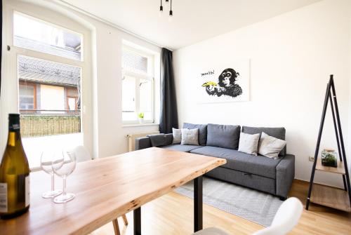 ein Wohnzimmer mit einem Sofa und einem Tisch in der Unterkunft Ko-Living - Händel Stuben - Street Art Design Apartments - Altstadt - zentral - Küche - Smart TV - mehrere Apartments - bis zu 6 P in Halle an der Saale