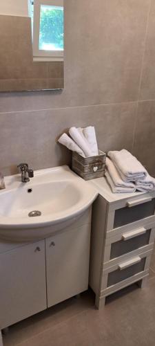 a bathroom with a sink and a mirror and towels at ANNA in Biograd na Moru