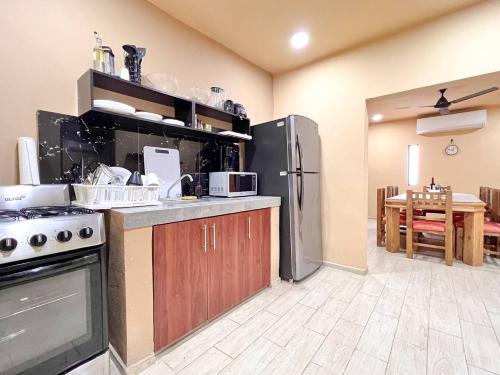 a kitchen with a stainless steel refrigerator and a table at Casa Xaan - Paraiso en Valladolid in Valladolid