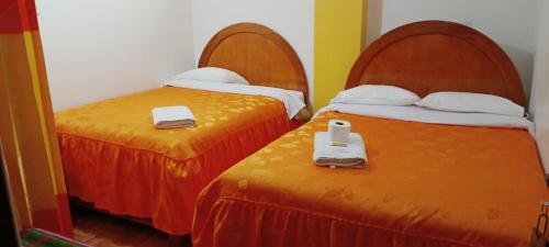 dos camas sentadas una al lado de la otra en una habitación en HOSTAL ACUARIUS PUNO, en Puno