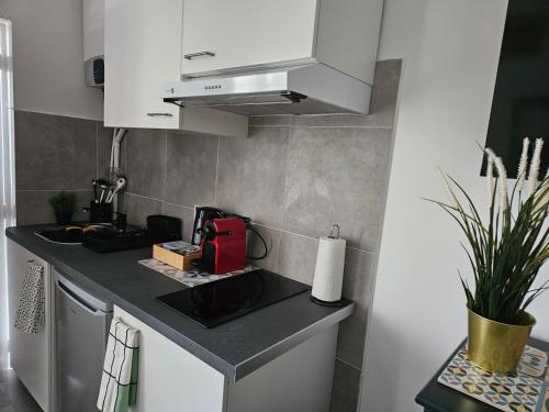 une petite cuisine avec des armoires blanches et un appareil rouge dans l'établissement studio Stade de France 17 pour 4 personnes, à Saint-Denis