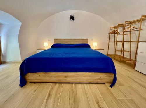 a bedroom with a large bed with a blue bedspread at La Stalla in Porto Santo Stefano