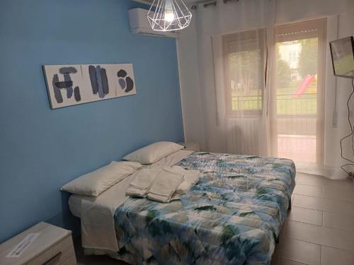 uma cama num quarto com uma parede azul em Casa Ester em Passo Corese