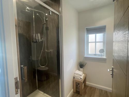 a shower stall in a bathroom with a window at Inverness luxury highland NC500 hideaway in Inverness