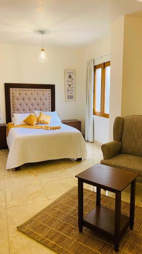 a bedroom with a bed and a couch and a table at Mansión Leonor in Bernal