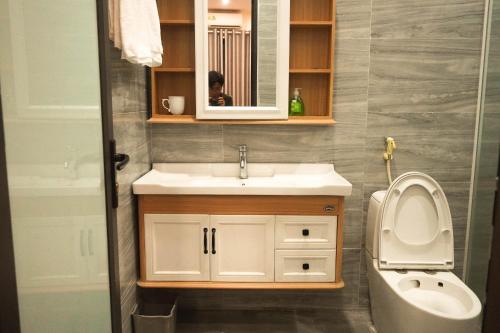 a bathroom with a sink and a toilet and a mirror at A Thía homestay in Diện Biên Phủ
