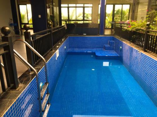 ein Pool mit blauen Fliesen in einem Gebäude in der Unterkunft A Thía homestay in Diện Biên Phủ