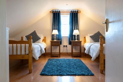 1 dormitorio con 2 camas y alfombra azul en Carna Chalet, en Galway
