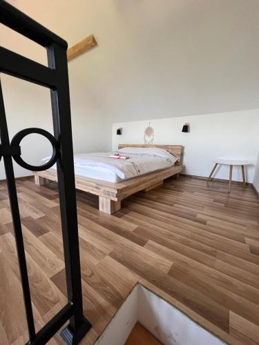 a bedroom with a bed and wooden floors at Zlatna Jabuka Lux in Prijepolje