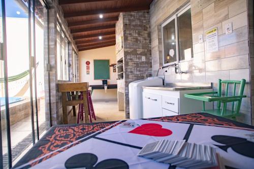 a room with a kitchen with a table and a sink at Casa Areal,1 Suíte, 2 Quartos Climatizados, piscina e Estacionamento 2 carros in Pelotas