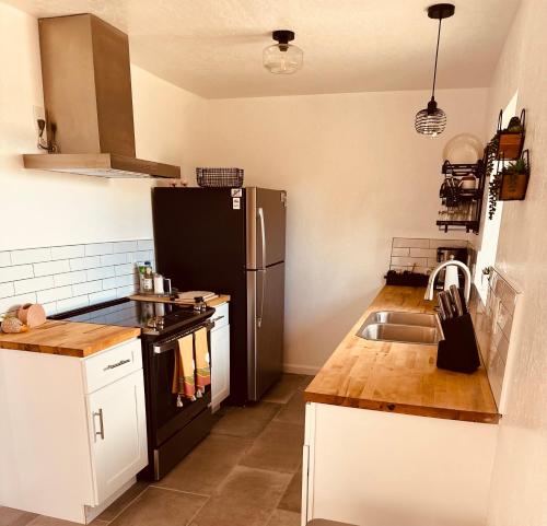 a kitchen with a black refrigerator and a sink at Adobe Hideaway House in Joshua Tree