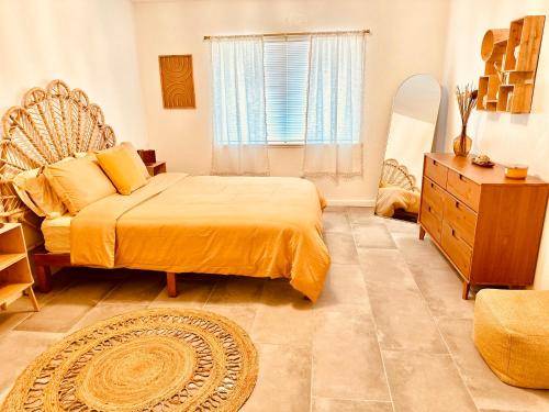 a bedroom with a bed and a dresser and a window at Adobe Hideaway House in Joshua Tree