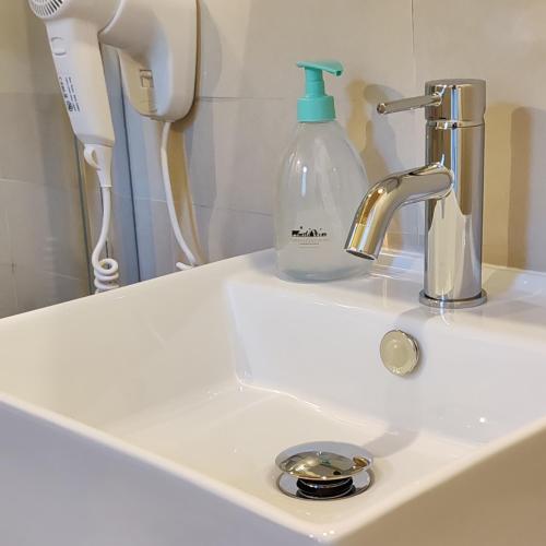 a bathroom sink with a soap bottle on it at Taverna Centomani in Potenza