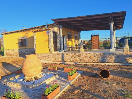 a house with a large vase and some plants at Casa Rural La Veguilla in Argés