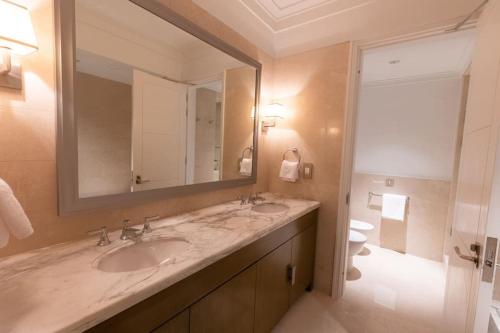 a bathroom with two sinks and a large mirror at the best charming condo on the Nile in Cairo