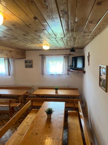 a dining room with wooden tables and benches at Cicha Dolina in Cisna