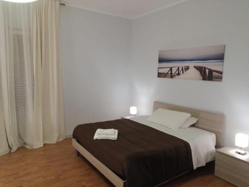 Un dormitorio con una cama con una manta blanca y negra. en Le Solite Holiday Rooms, en SantʼEufemia Lamezia
