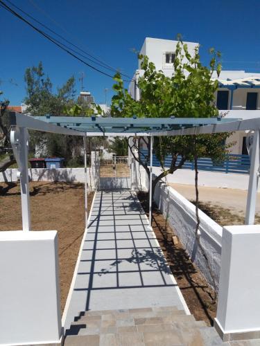 a walkway leading up to a beach with a white pergola at Skala Central House in Skala