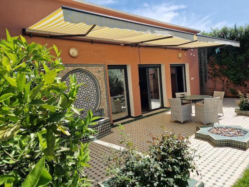 a house with a patio with a table and chairs at Villa Palmengarten Meknès bei Fes in Meknès