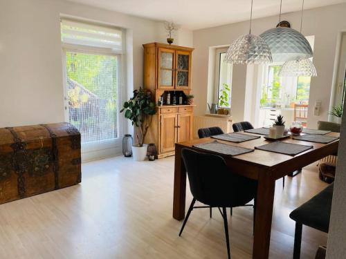 sala de estar con mesa de madera y comedor en Ferienwohnungen mitten im Grünen, en Löhnberg