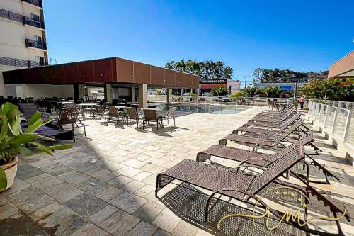 a group of chairs and tables and a building at Spazzio diRoma RM Hospedagem com Acesso Acqua Park/Splash in Caldas Novas