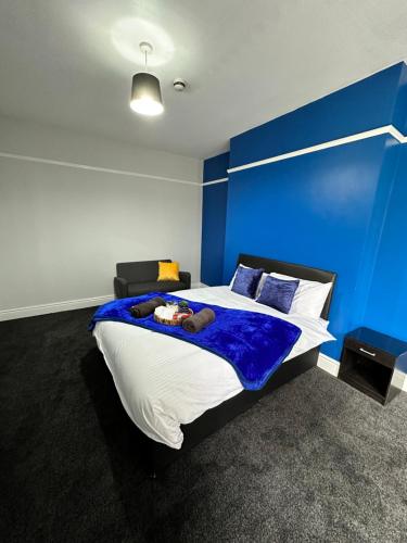 a bedroom with a large bed with a blue wall at Quirky Oasis Queens in Liverpool