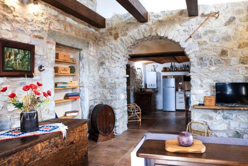 una cucina e un soggiorno con parete in pietra di Ca'Toni a Bagnone
