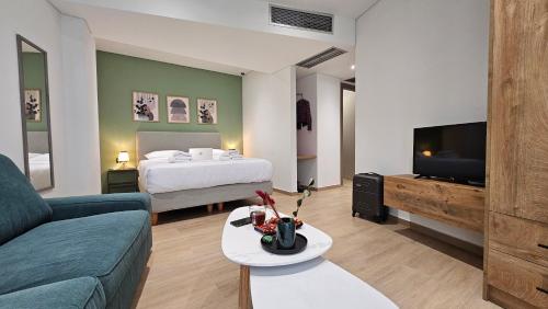 sala de estar con sofá, cama y TV en Sezame ApartHotel en Ioánina