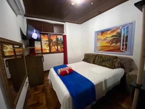 1 dormitorio con 1 cama con manta azul en Kitinete Ipanema, en Río de Janeiro