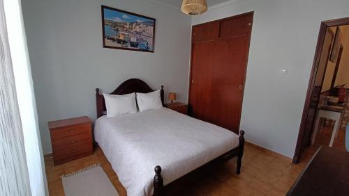 - une petite chambre avec un lit et une armoire en bois dans l'établissement AL Bela Vida, à Tavira