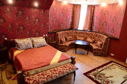 a living room with a red couch and a red bedspread at Oazis-M in Babin