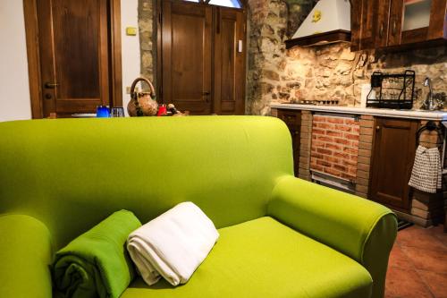 a green couch in a kitchen with a counter at Ca' Tonino in Bagnone