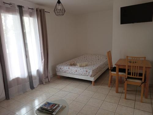 - une chambre avec un lit, une table, une table et une chaise dans l'établissement Appartement Côté Rocher, à La Garde