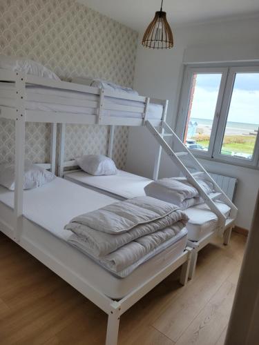 deux lits superposés dans une chambre avec fenêtre dans l'établissement Le Solemare Appartement T3 Face Mer Cayeux sur Mer, à Cayeux-sur-Mer