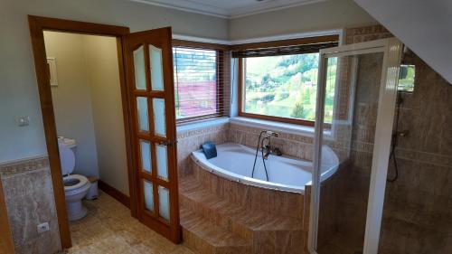 een badkamer met een bad en een raam bij Zawóz 20 in Zawóz