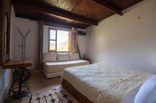 a bedroom with a bed and a window at Dar l'eau Vive in Bine el Ouidane