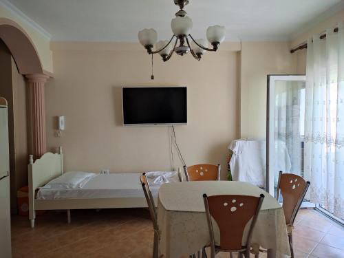 a dining room with a table and a tv on the wall at Apartment in Lungo Mare Vlore in Vlorë