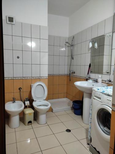 a bathroom with a toilet and a sink and a washing machine at Apartment in Lungo Mare Vlore in Vlorë