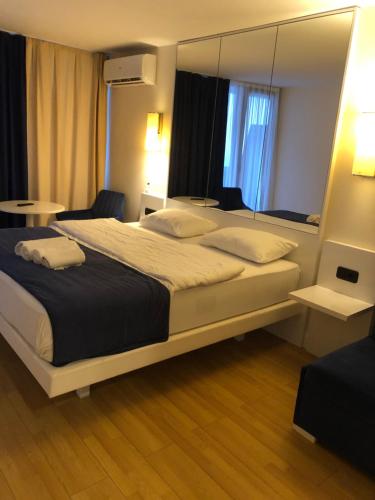 Una habitación de hotel con una cama grande y un espejo. en orbi blu apart otel, en Batumi
