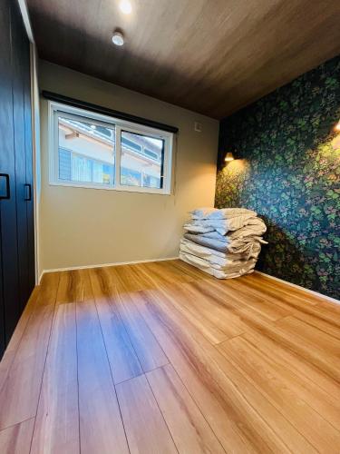 an empty room with a wooden floor and a window at 村の小さなお宿　おきな in Tosa