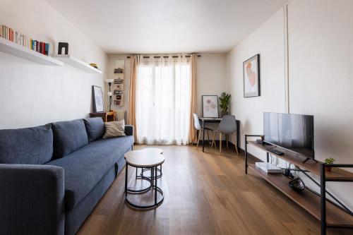 un salon avec un canapé bleu et une télévision dans l'établissement Confort à 10 minutes de la Gare de Lyon, à Maisons-Alfort