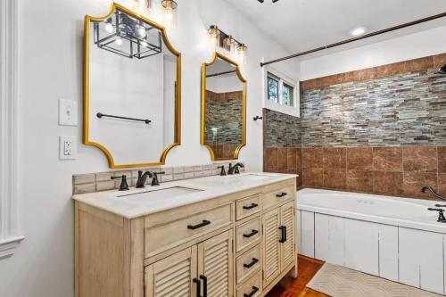 a bathroom with a sink and a tub and a mirror at Pawleys Island Retreat 4 Bedroom Haven in Pawleys Island