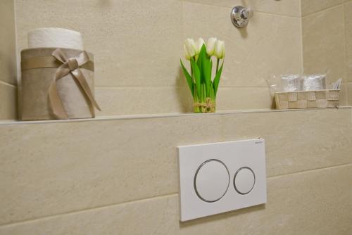 a white sign on a wall with flowers and towels at Zoilo Rooms self check-in in Zadar