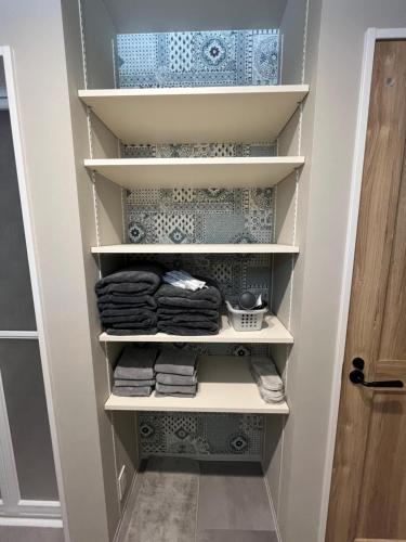 a walk in closet with white shelves and blue and white tiles at 村の小さなお宿　おきな in Tosa